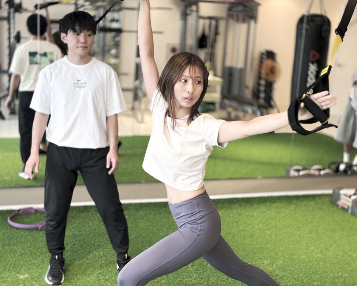 トレーナーと身体を動かす女性